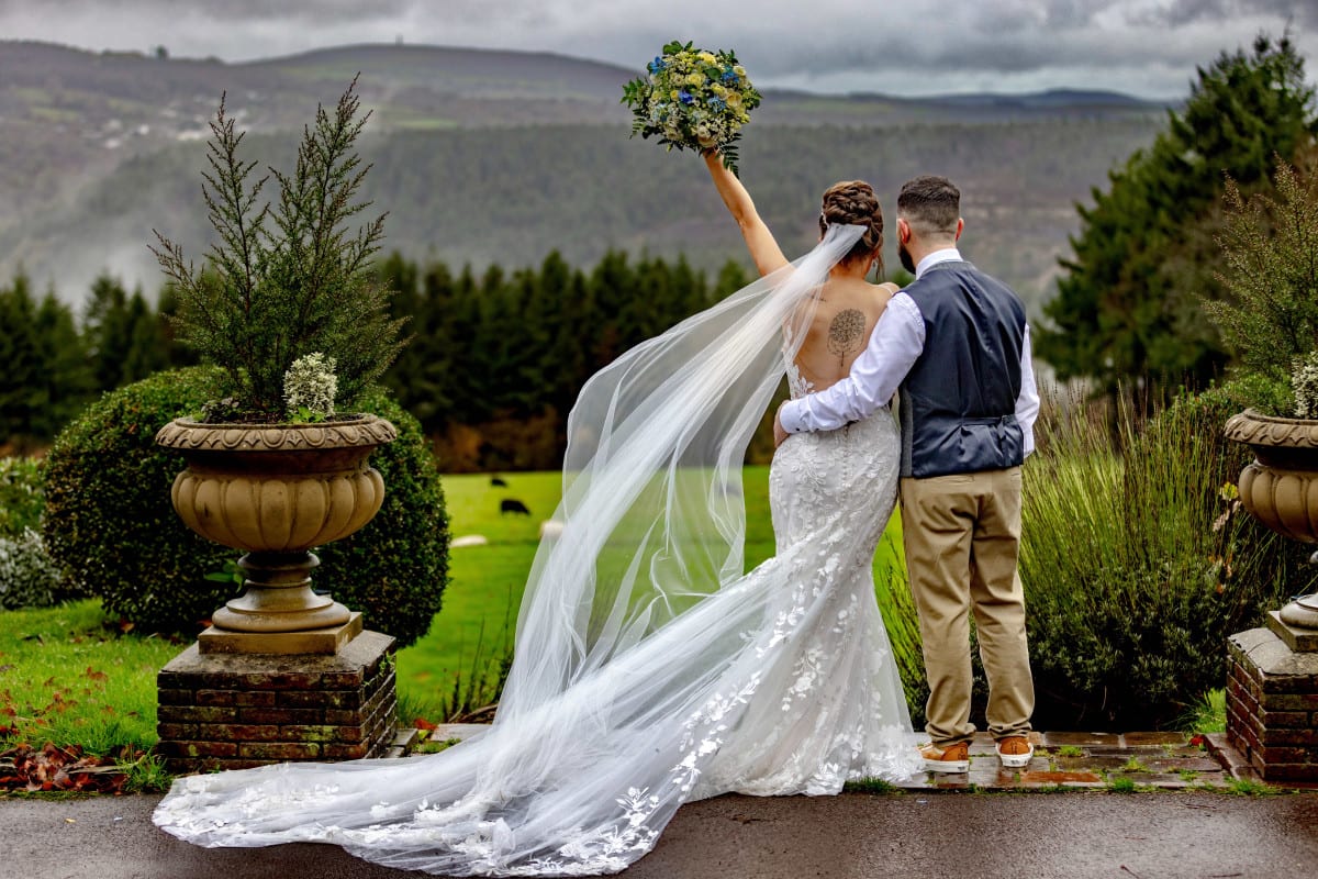 winter's day wedding showing bride in a a full lace dress with billowing veil
